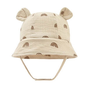 Detail of baby cotton sun hat with cute ears and brown rainbow print on beige gauze fabric
