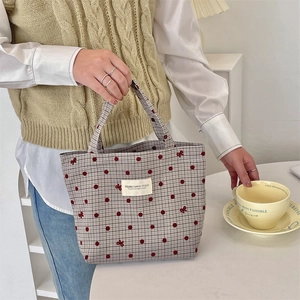 Gros plan du petit sac à main en toile avec des pois rouges et un nœud en scène de vie