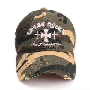 Casquette de baseball camouflage avec broderie croix rose et bords usés.
