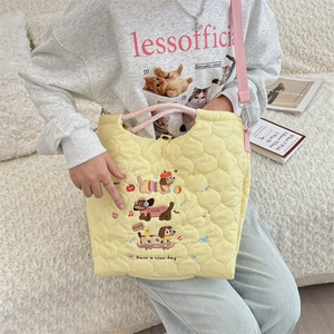 Detail of cute puppy embroidery and quilted fabric texture on the yellow tote bag