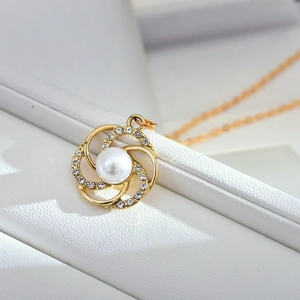 Collier élégant en or avec pendentif perle de camélia et zircons sur boîte à bijoux