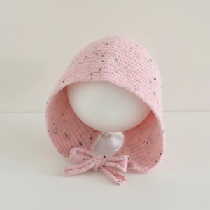 Détail du bonnet en tricot rose avec taches noires et nœud tricoté pour filles