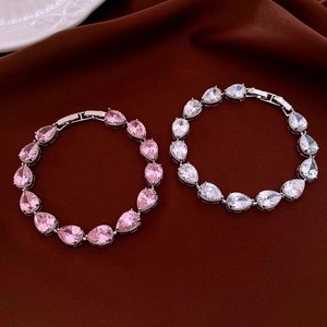 Close-up of pink and white teardrop zircon bracelets with secure clasp on silk background
