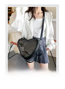 Detail of a black heart-shaped Ita bag with clear window and adjustable strap