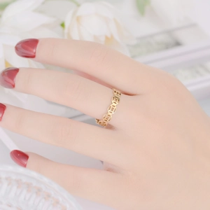 Close-up detail of a gold Chinese copper coin ring on a finger for wealth and luck