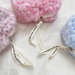 Close-up of heart-shaped leopard print plush pouches in pink, lilac, and blue hues