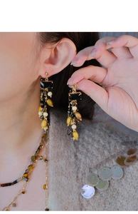 Detailed view of long ethnic style tassel earrings with wooden beads and black stones