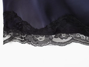 Gros plan détaillé de la robe en satin bleu marine avec dentelle noire et texture soyeuse