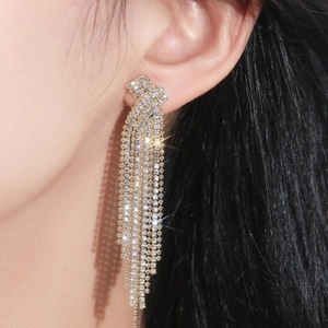 Elegant long tassel earrings with sparkling zircon crystals in gold finish on model