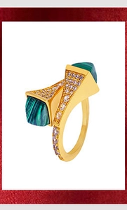 Macro detail of gold-plated bangle with green malachite stone and sparkling crystal accents