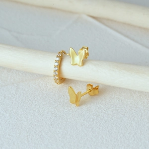 Macro shot of 925 sterling silver butterfly earrings and zircon hoop set in gold