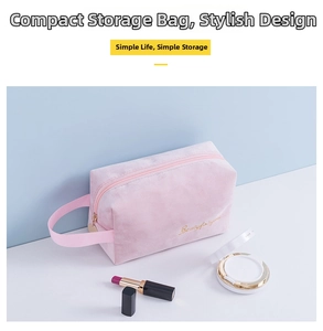 Detailed view of pink velvet makeup bag with gold embroidery and a side handle strap