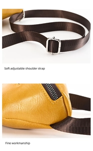 Detail view of adjustable fabric shoulder strap and fine sewing on yellow leather bag