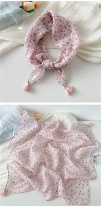 Detail of pink floral cotton linen scarf featuring delicate print and fringe tassels