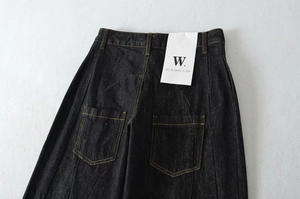 Dettaglio vita posteriore di jeans scuri con tasche classiche e cuciture a contrasto