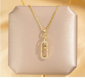 Détail du pendentif géométrique serti de zircons sur une chaîne élégante en or fin