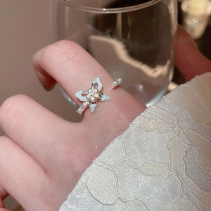 Détail de la bague papillon en émail bleu avec perles blanches et zircon au doigt