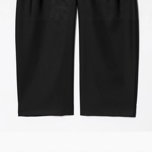 Pantalon large noir fluide avec détails de l'ourlet et texture en tissu tissé