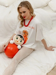 Λεπτομέρεια από λευκό βαμβακερό t-shirt με τύπωμα ρωσική κούκλα και κόκκινο κολιέ με χάντρες