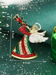 Detail of Christmas angel brooch with rhinestones and enamel on festive background