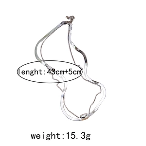 Detail of silver double-layer necklace with flat snake chain, C-link and pearl accent