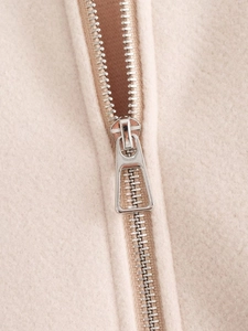 Close-up of high-quality silver metal zipper on beige wool coat fabric detail