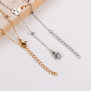 Detail of gold and silver dainty anklets with love heart pendant and sparkling crystals