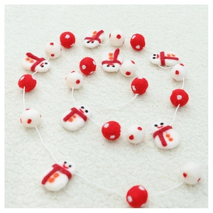 Close-up of red and white wool felt snowman garland for Christmas tree decoration