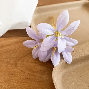 Elegant purple fabric flower hair pin with golden U-shaped clip and dewdrop detail
