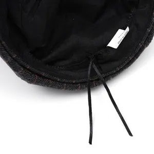 Plaid newsboy hat interior detail with adjustable drawstring and soft black lining