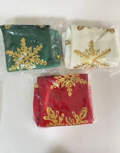 Detailed view of red, white, and green velvet Christmas stockings with gold snowflake sequins