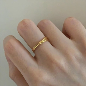 Detail of a minimalist gold knot ring with a sleek polished finish on a model finger