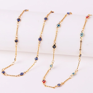 Detailed macro view of gold plated necklaces featuring blue and red devil eye beads