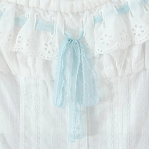 White off-shoulder top with light blue lace bow and intricate embroidery detail