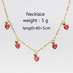 Detailed view of cherry pendant necklace with red cubic zirconia on gold chain