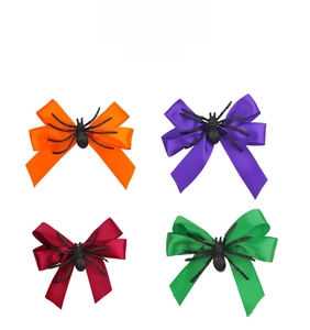 Détail des barrettes nœuds d'Halloween en orange, violet, rouge et vert avec décor araignée