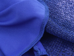 Vista macro delle cuciture in maglia blu e tessuto a rete su un abito da sera