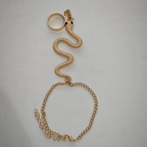 Dettaglio del bracciale ad anello a serpente dorato con un intricato design a catena e serpente