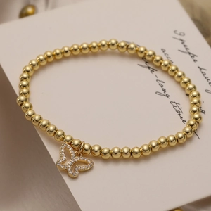 Elegant gold-plated beaded bracelet with a sparkling zircon butterfly pendant on a box