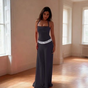 Detailed close-up of a deep purple floor-length dress with a shimmering silver sequin belt