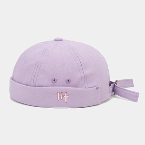 Detailed view of lavender cotton docker cap featuring lit letter embroidery and adjustable strap