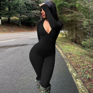 Detail of black ribbed knit jumpsuit with a deep V-neckline shown in an outdoor setting