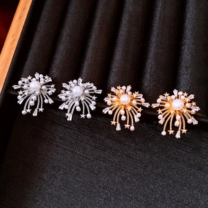 Macro shot of 18k gold fireworks earrings with pearls and zircon in black velvet case