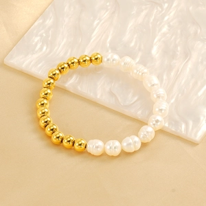 Baroque pearl and 18k gold plated steel bead bracelet on a minimalist textured background