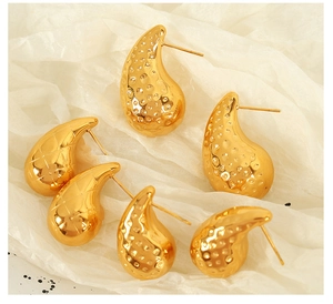 Detail of 18K gold-plated teardrop earrings with honeycomb and diamond texture patterns