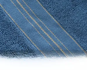 Macro shot of blue cotton towel showing premium knit texture and gold thread weave detail