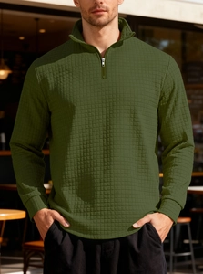 Detail of olive green waffle knit texture and half-zip stand collar on men's sweater
