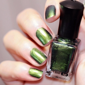 Macro shot of MY DANCE chameleon nail lacquer in dark green with gold shimmer
