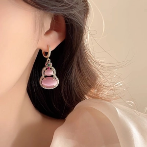 Close-up of pink gourd drop earrings with 14k gold plating worn by a female model