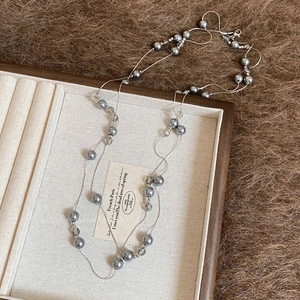 Detail of layered grey pearl and tiger eye beaded necklace in a vintage jewelry box
